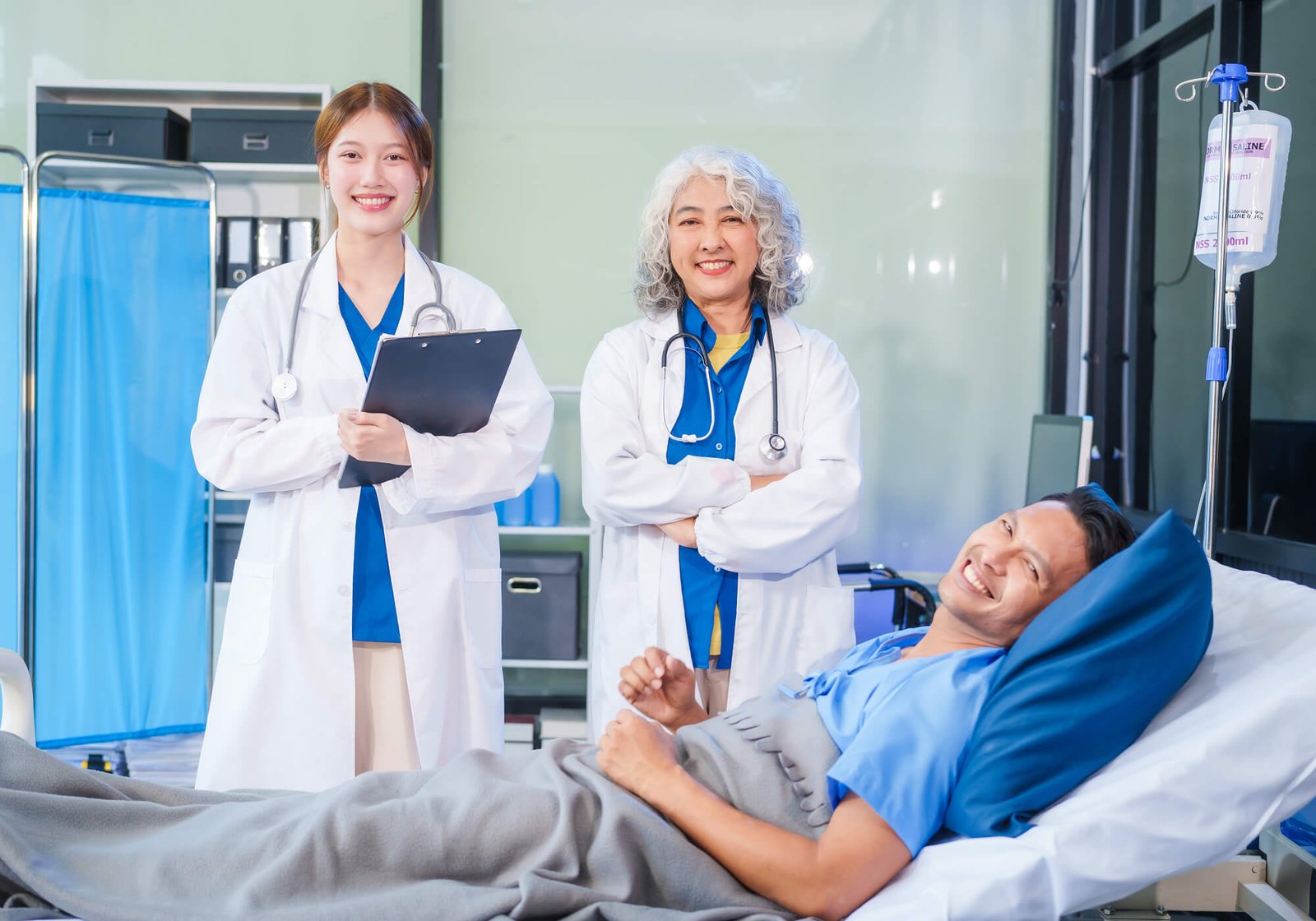 two-female-doctors-examine-a-patient-lying-on-a-ho-755PHHS.jpg